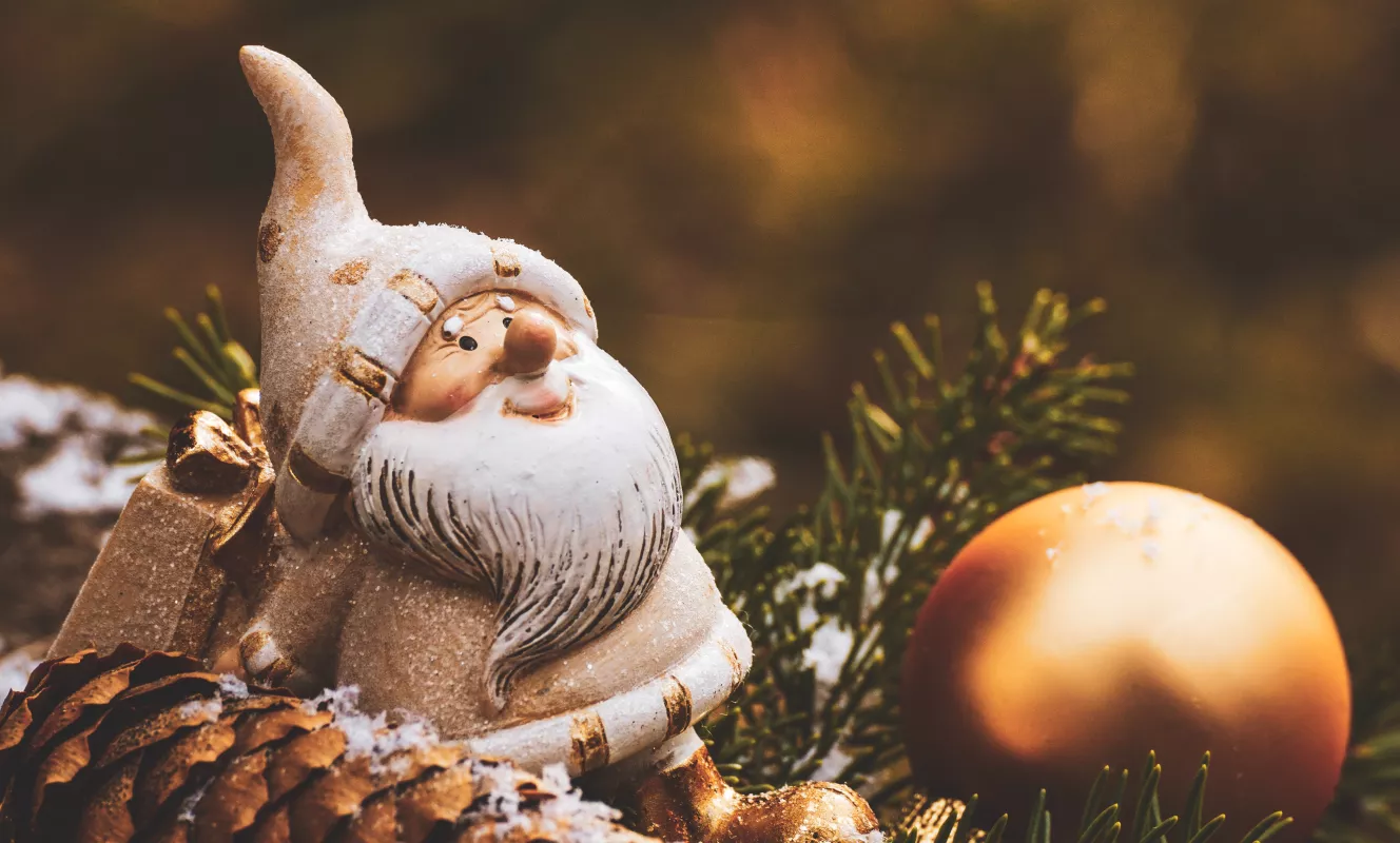 Foto van een kerstman en een kerstbal. Studio Globo wenst iedereen fijne feestdagen.