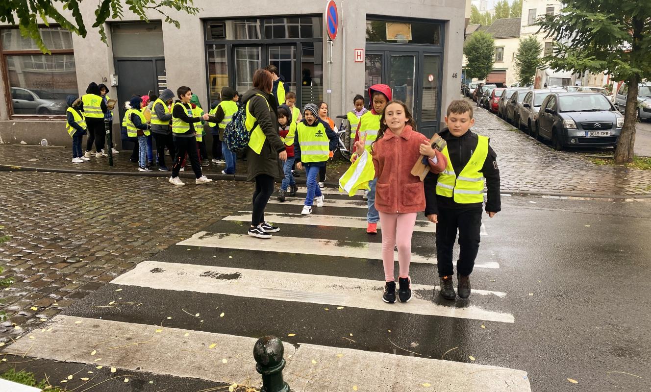 Foto van leerlingen die de straat oversteken tijdens de buurtwandeling in Brussel van Studio Globo.